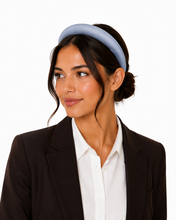 Load image into Gallery viewer, Woman wearing blue satin padded headband with low bun against a white background