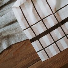 Load image into Gallery viewer, Close-up of a folded fabric with a grid pattern on a wooden surface
