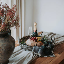 Load image into Gallery viewer, Table setting with bread, wine, and fruit on a wooden table with a rustic decor.